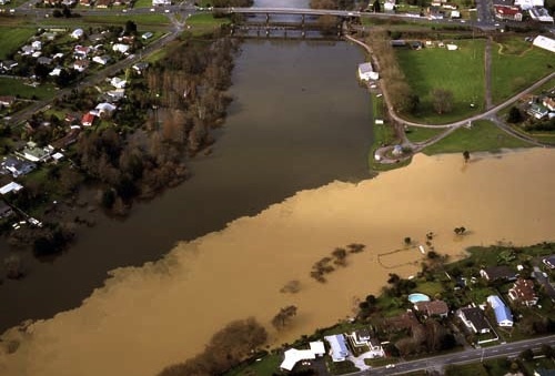 Aerial photo of a muddy, sediment-filled river joining with a clear river in a Y-shape.